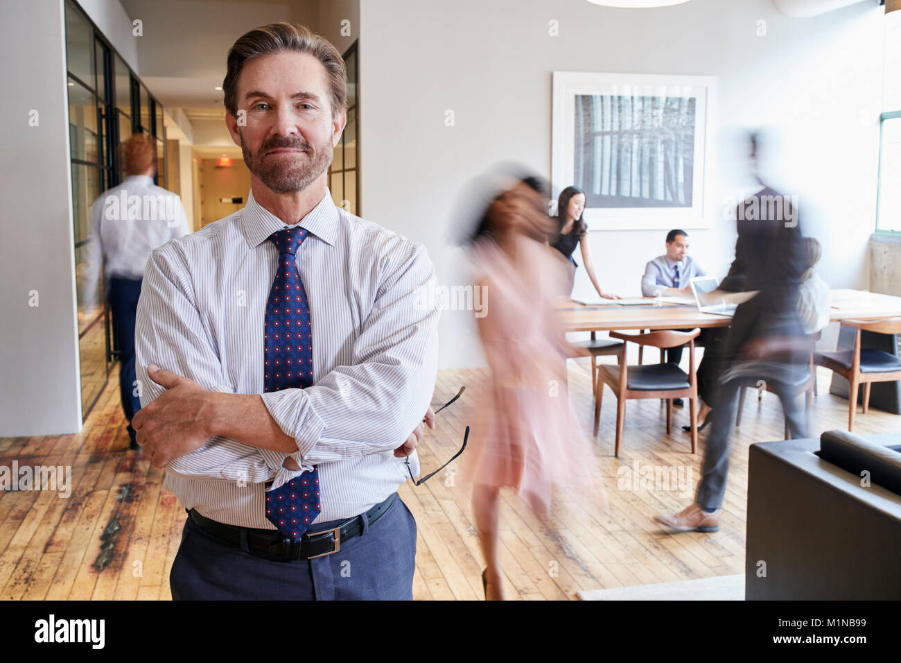 Portrait of middle aged white man in a busy modern workplace Stock Photo