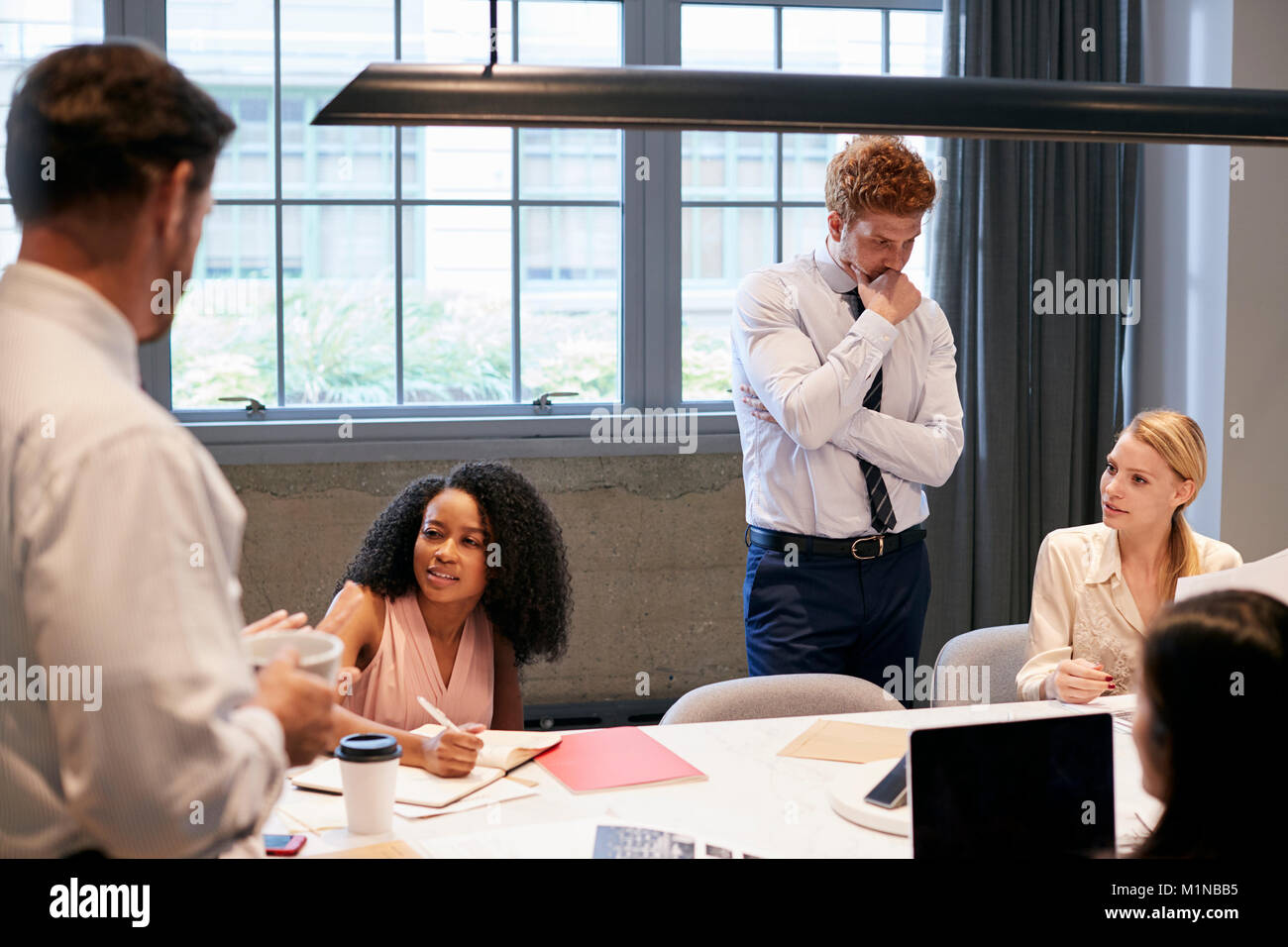 Business colleagues brainstorming together in a meeting room Stock ...