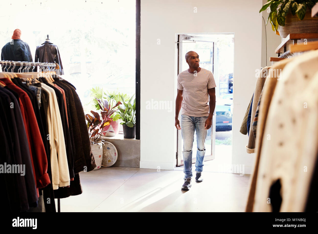 Young black man walking into a clothes shop Stock Photo