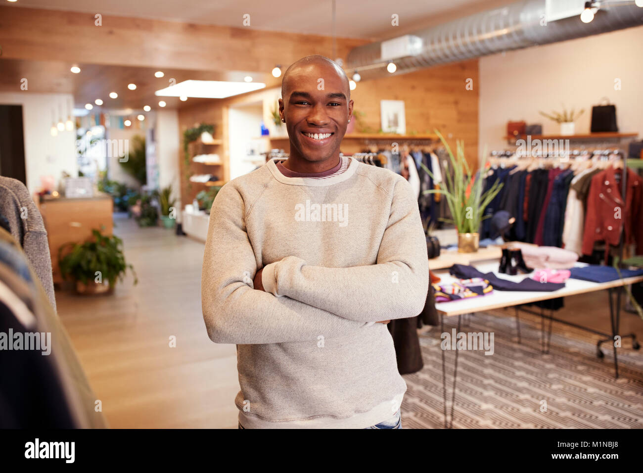 Young black man smiling to camera in a clothes shop Stock Photo