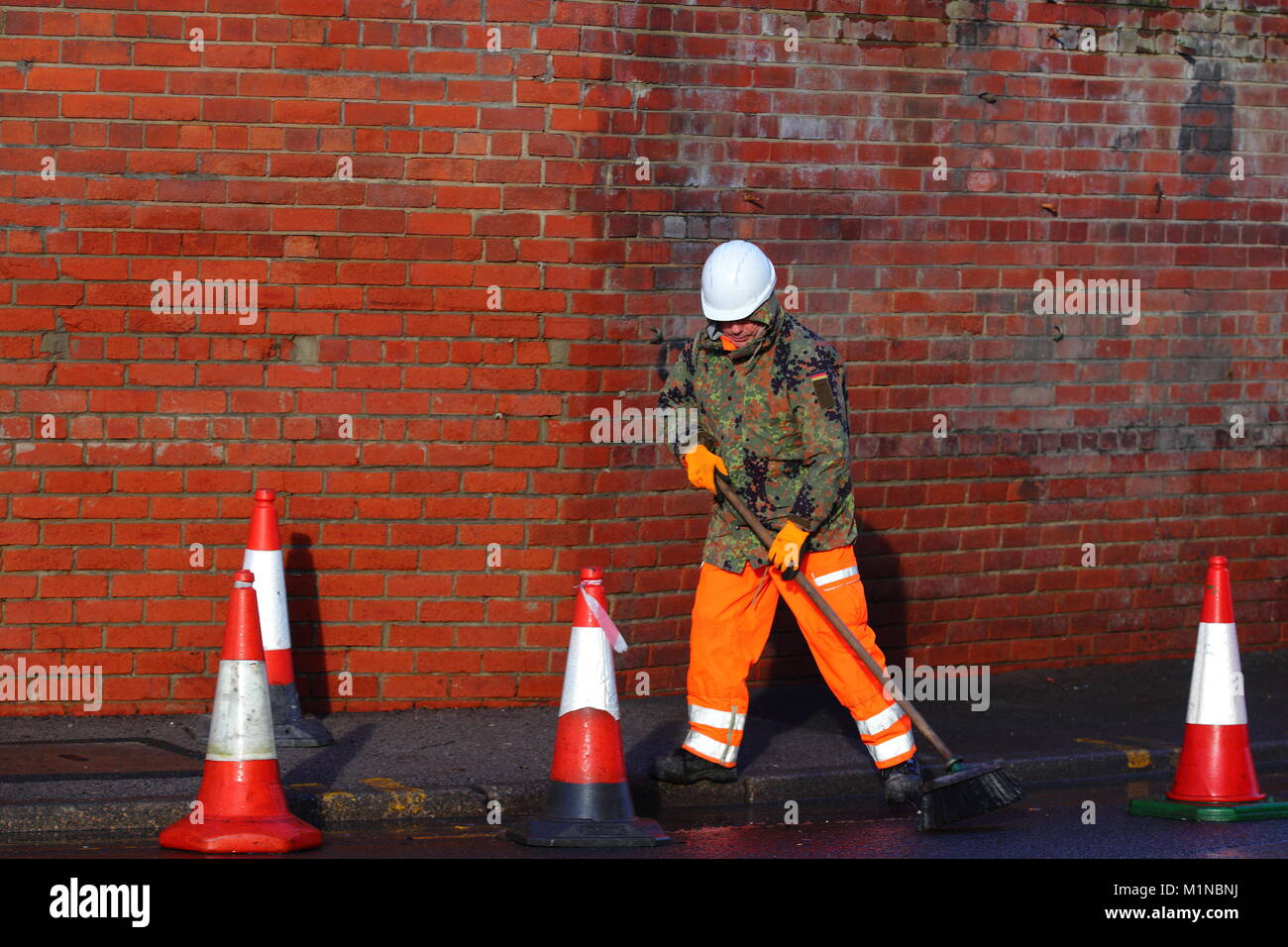 A workman can't make his mind up whether he wants to be seen or not. Stock Photo