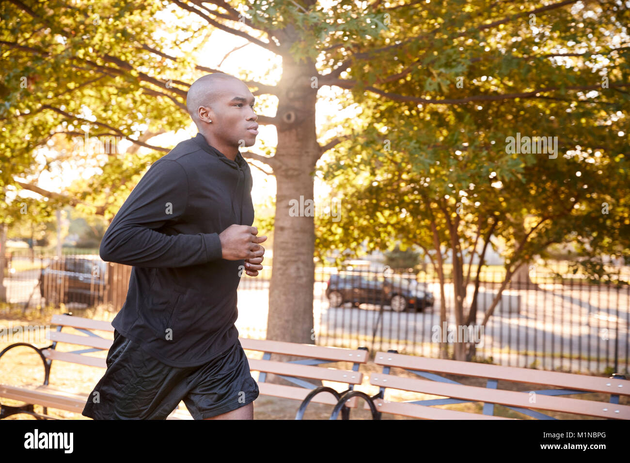 Young black man jogging in a Brooklyn park, close up Stock Photo