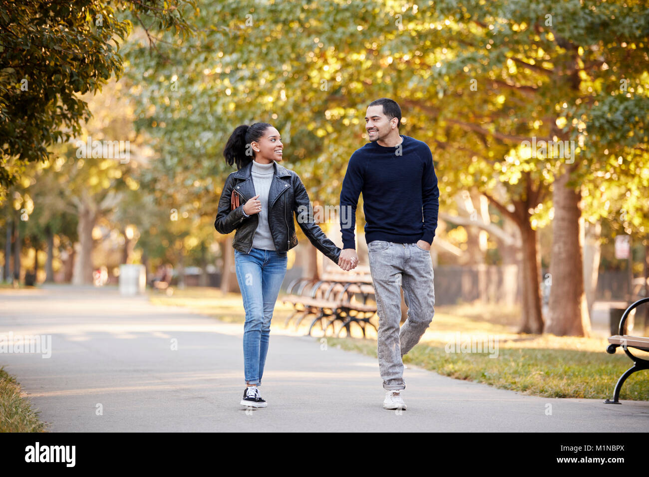 Young Hispanic couple walking hand in hand in Brooklyn park Stock Photo ...