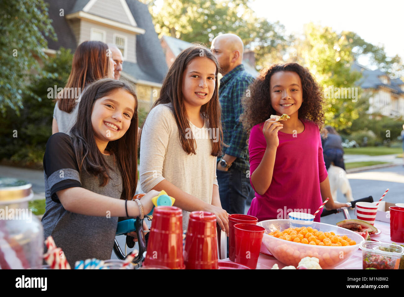 Pre-teen girls smiling to camera at a block party, close up Stock Photo