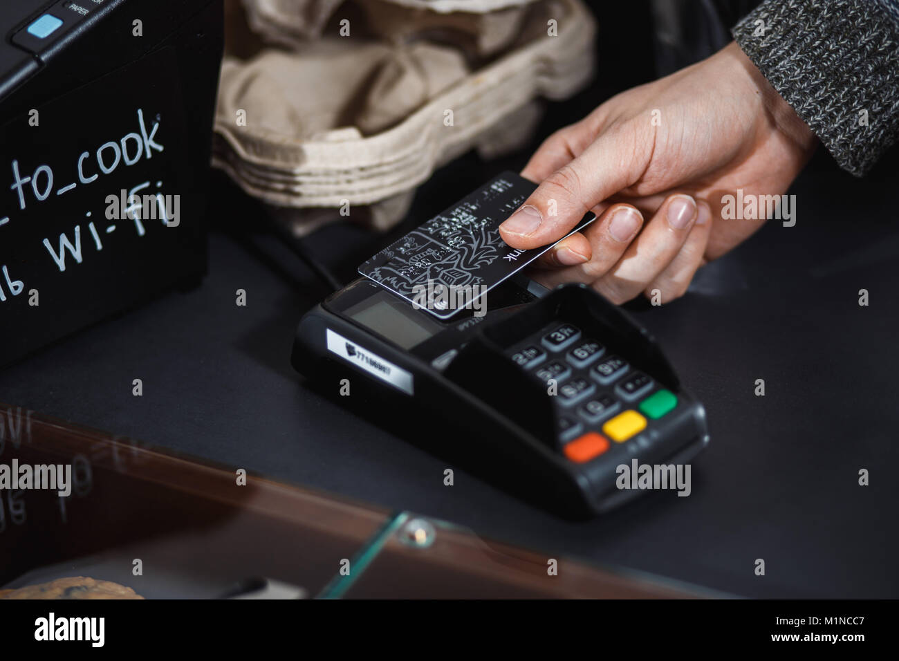 Customer is paying with contactless credit card in shop. Stock Photo