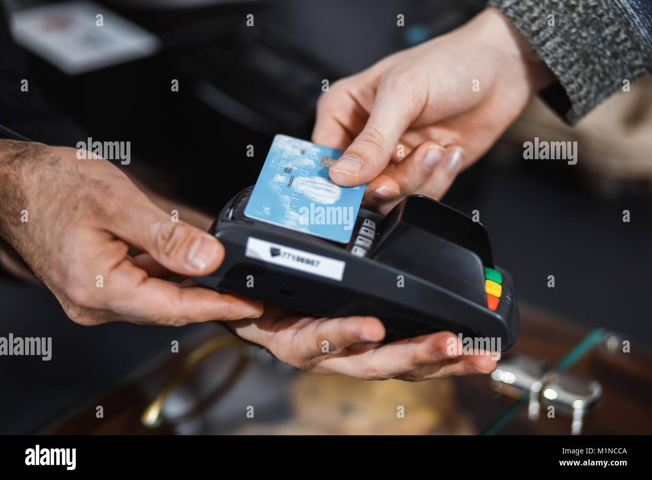 Customer is paying with contactless credit card in shop. Stock Photo