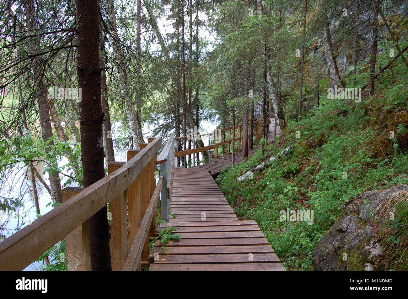 Wooden gangway along a steep mountain slope on a tourist route in a natural park Stock Photo