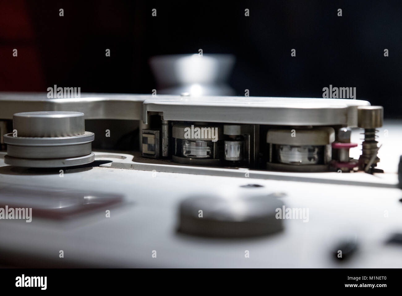 Macro close up of vintage professional analog multitrack one inch studio tape recorder, spool