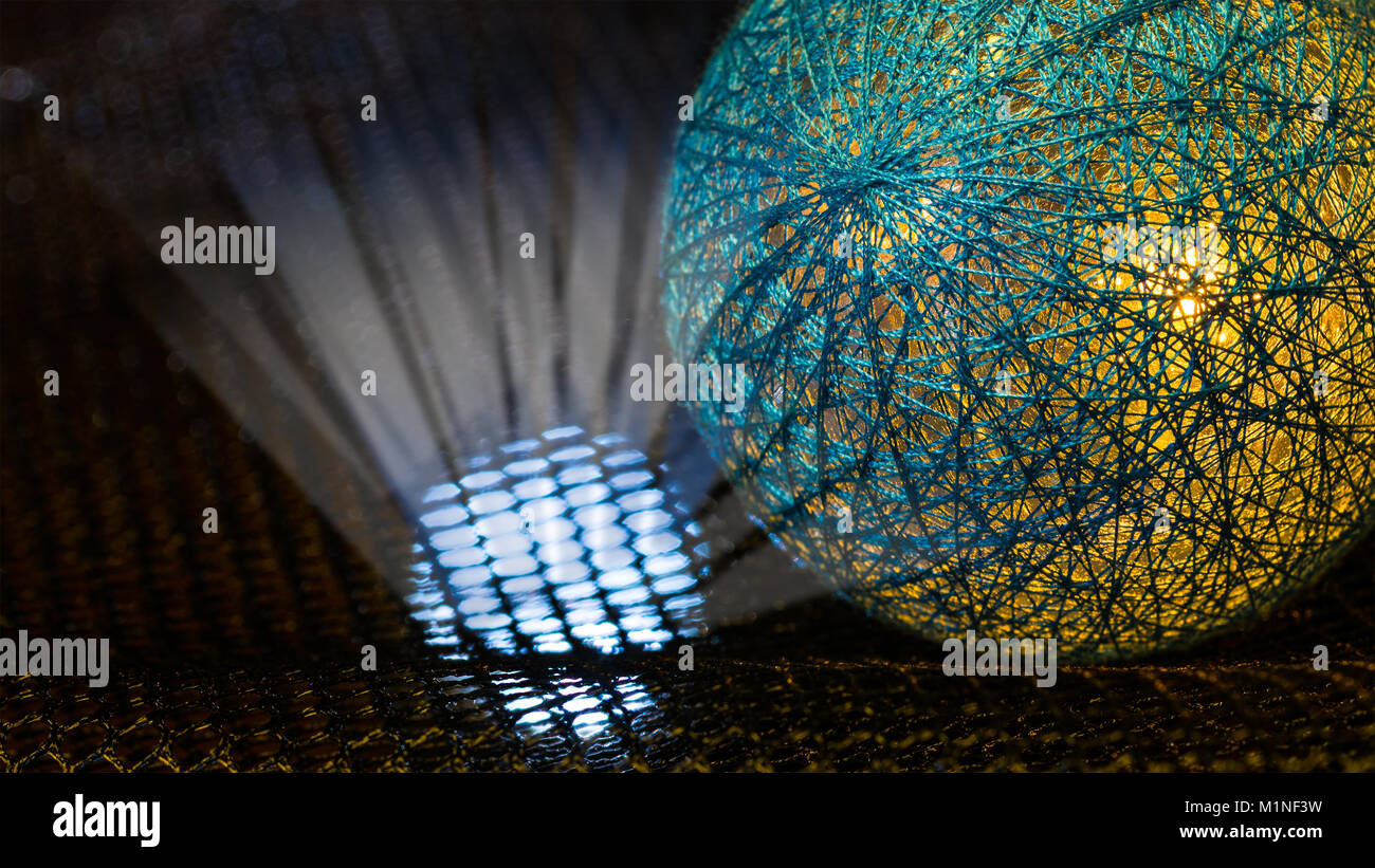 Detail of a sphere covered by net from fibers and mystery light rays in black space. Idea of danger, nuclear weapons, radiation, technology or sci-fi. Stock Photo
