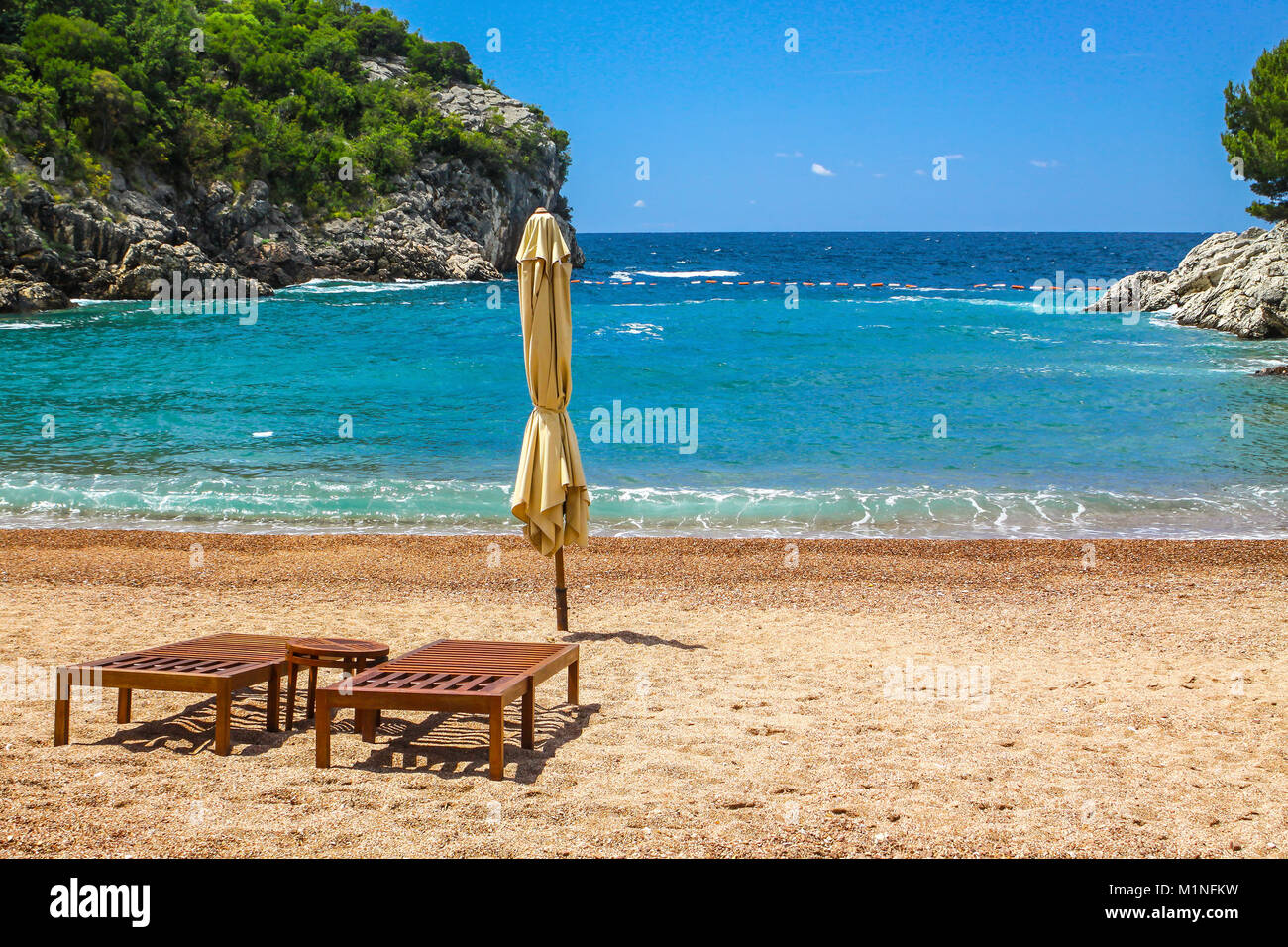 Empty summer sea beach with two chairs. Queen's Beach (Kraljicina Plaza) near Sveti Stefan, Montenegro Stock Photo