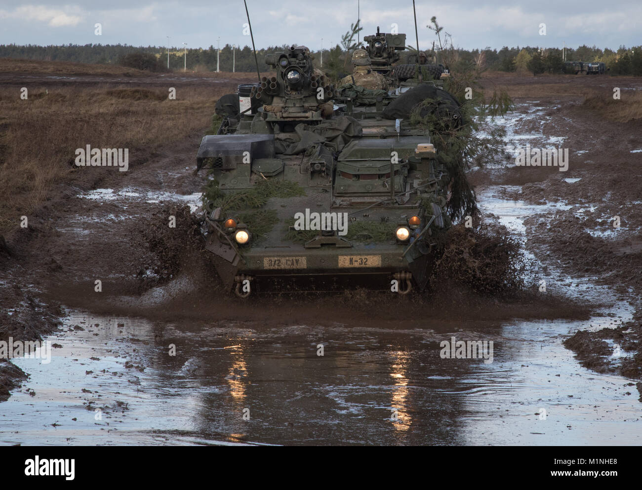 U.S. Soldiers from Kronos Troop, 3rd Squadron, 2nd Cavalry Regiment, drive their Strykers to their battle positions as they participate in a mounted NATO live fire exercise coordinated by the Polish 1st Battalion 15th Mechanized Brigade at a range near the Bemowo Piskie Training Area, Poland, Jan. 30, 2018. The unique, multinational battle group, comprised of U.S., U.K., Croatian and Romanian soldiers serve with the Polish 15th Mechanized Brigade as a deterrence force in northeast Poland in support of NATO’s Enhanced Forward Presence. (U.S. Army photo by Spc. Andrew McNeil / 22nd Mobile Public Stock Photo