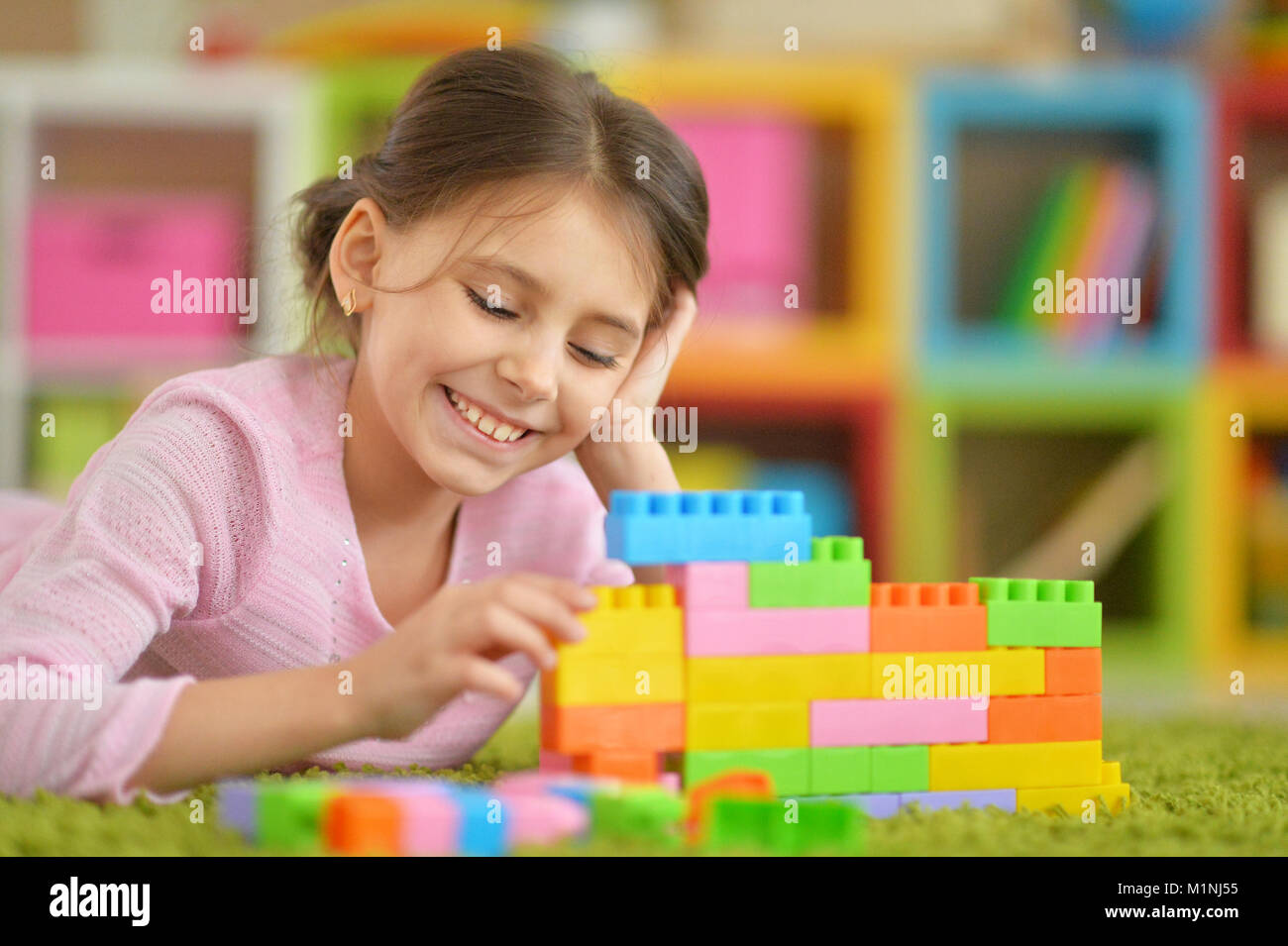 little girl with colorful plastic blocks Stock Photo - Alamy