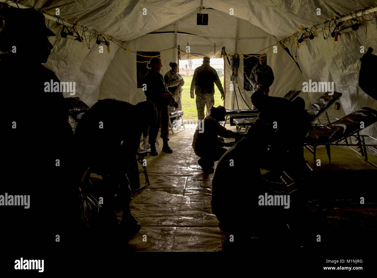 Airmen assigned to the 60th Medical Group set up cots in an EnRoute Patient Staging System at