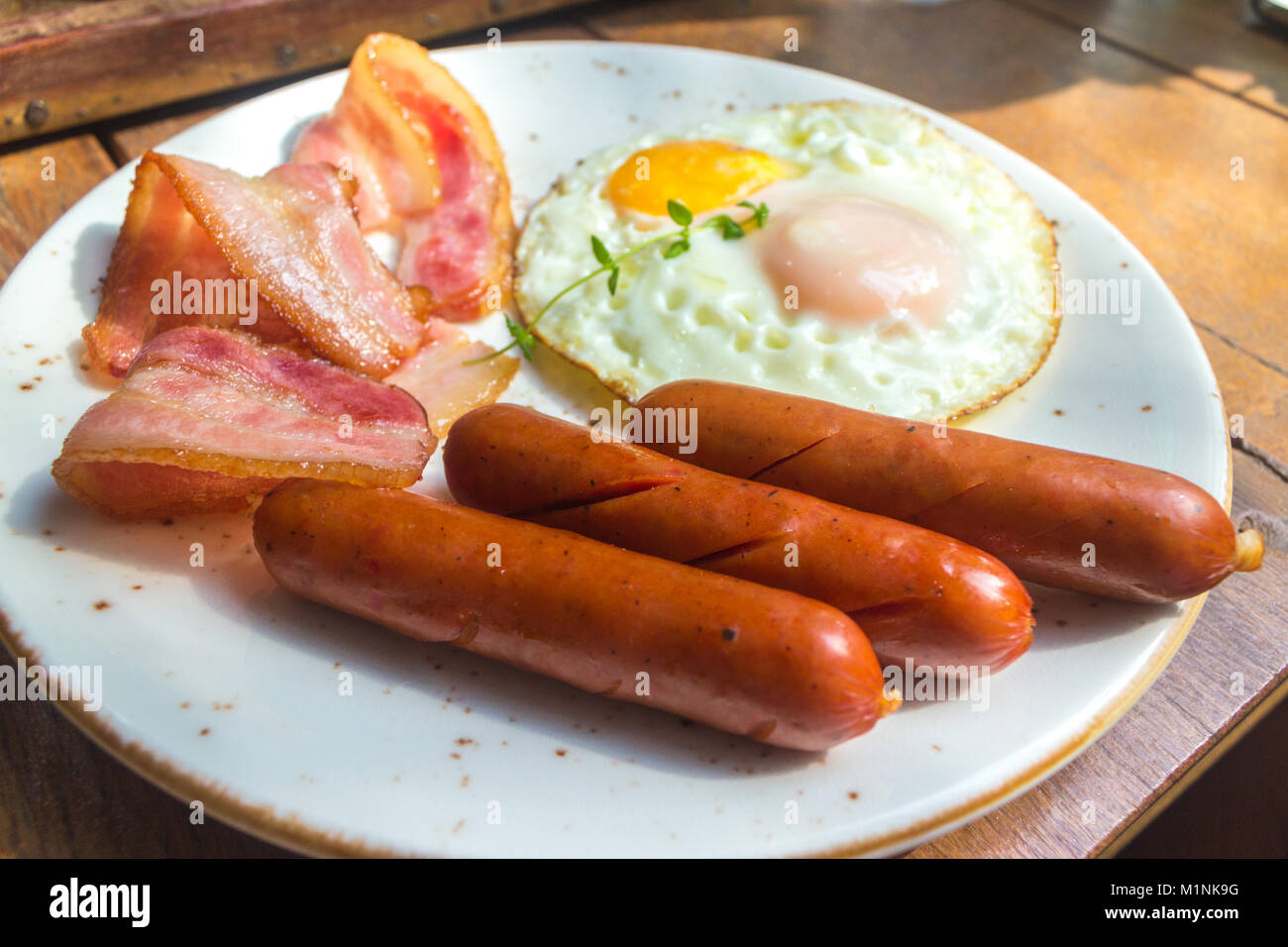 Set of american breakfast with bacon, fried eggs and sausage on wood table background Stock Photo