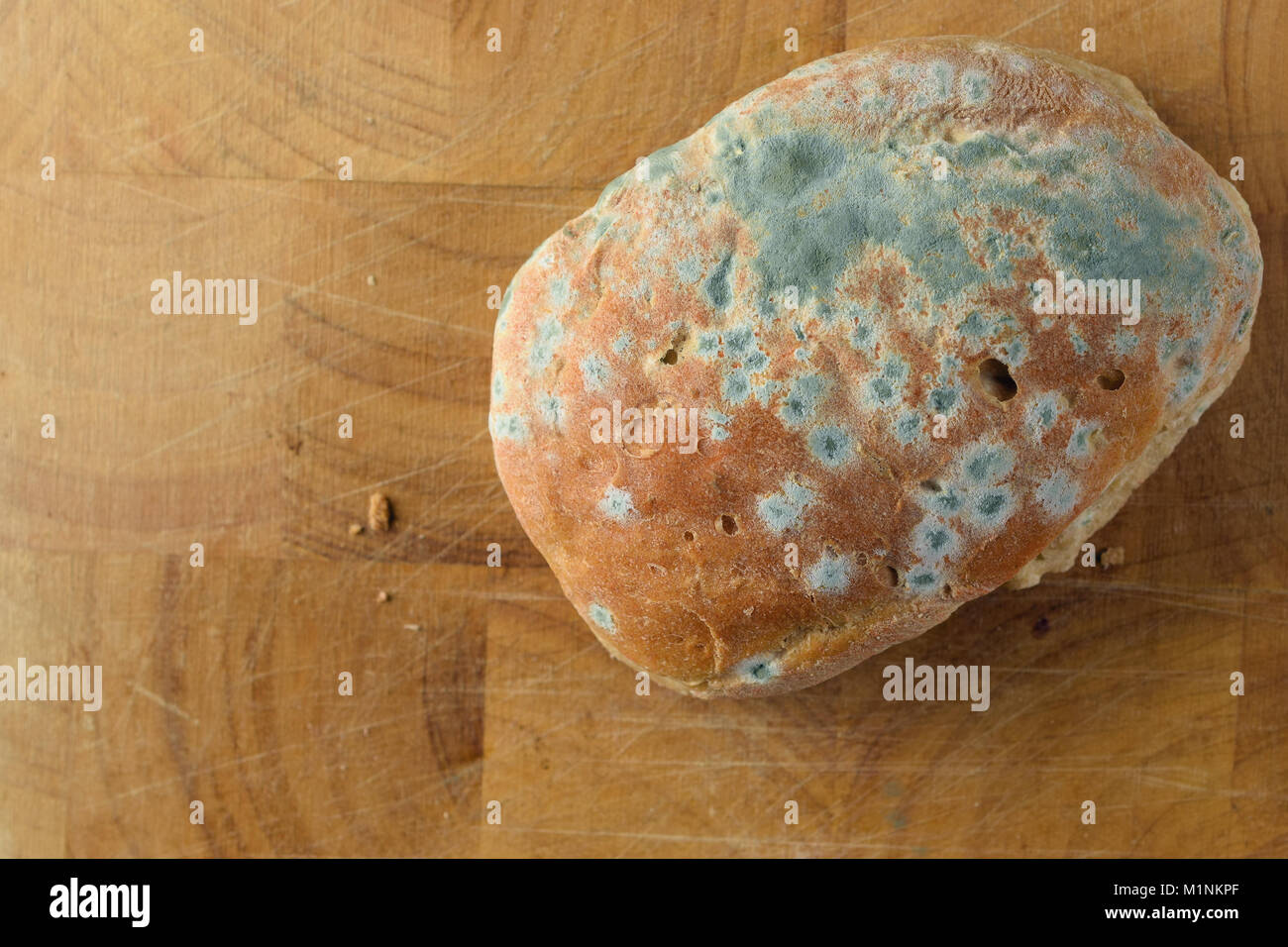 Moldy bread on wooden surface. Top view with space for text. Stock Photo