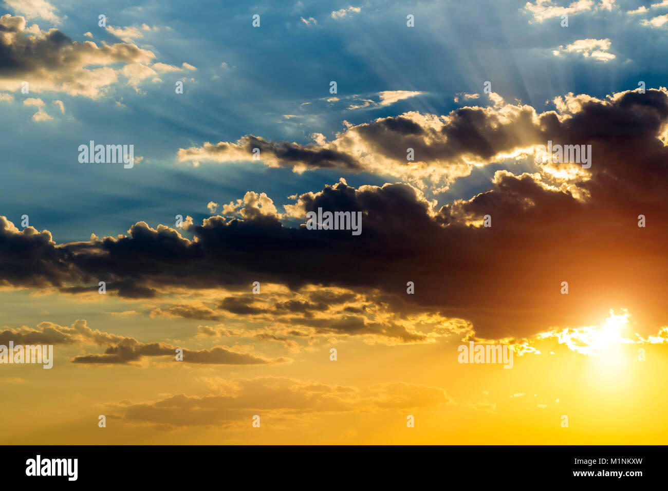The sun hid behind black clouds and its rays beat up Stock Photo - Alamy