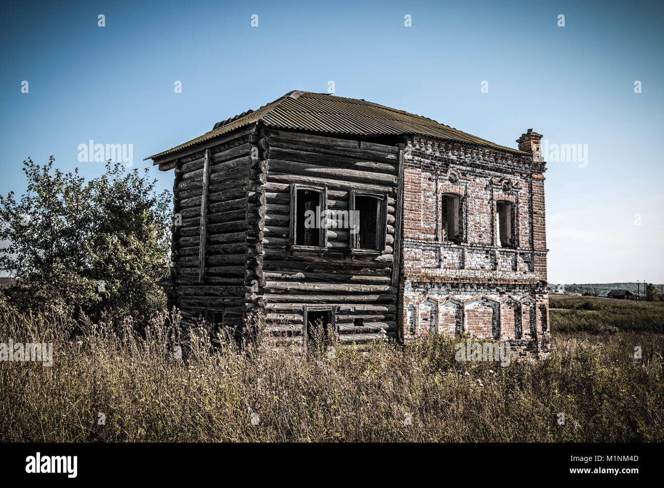 The old abandoned historic building of red brick and logs Stock Photo ...