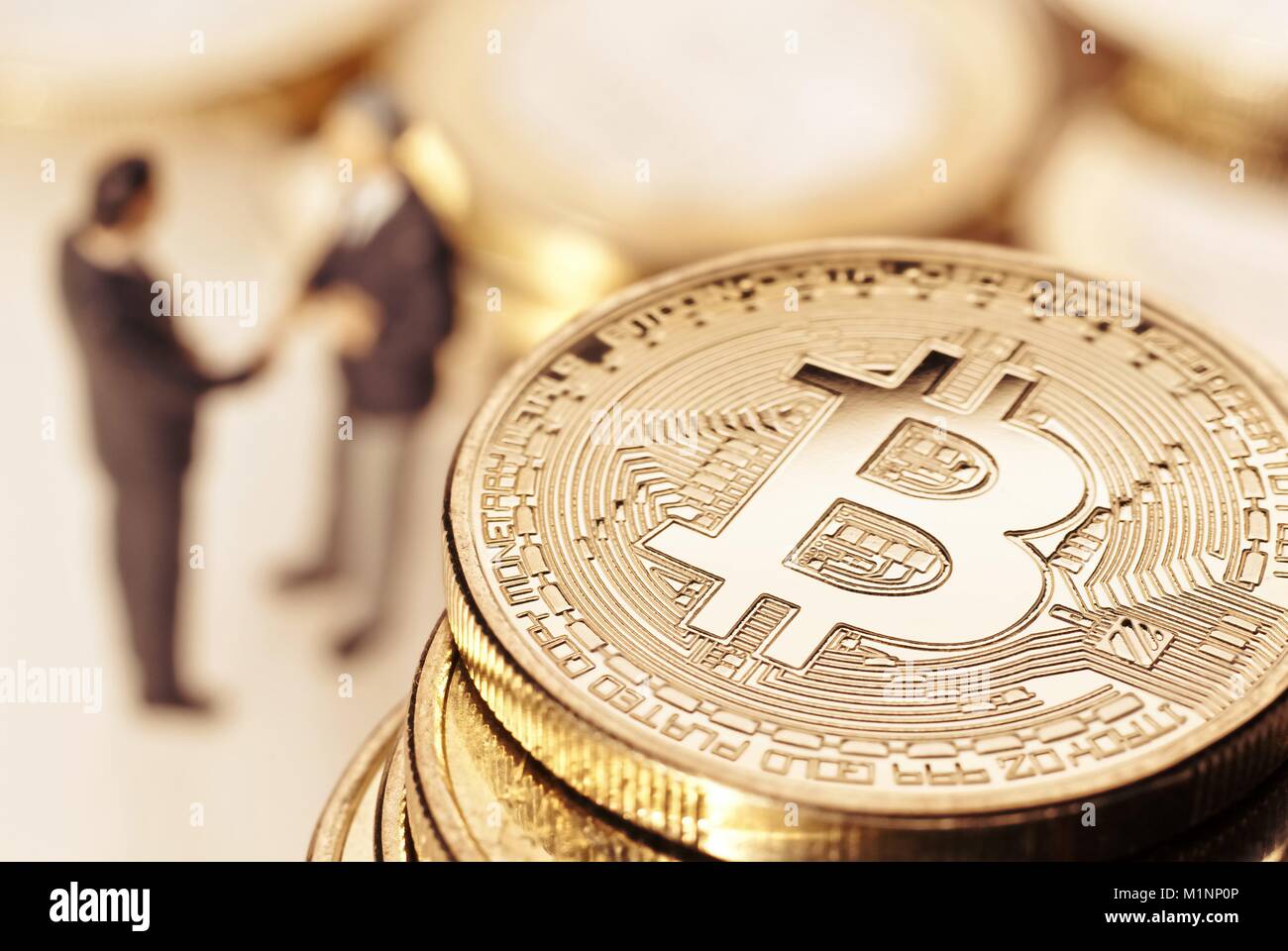 Bitcoin and businessmen in the background shaking hands. | usage worldwide Stock Photo