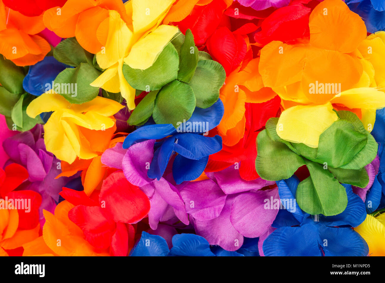 Bright jumble of flower Carnival leis in rainbow colors in a full frame textured background Stock Photo