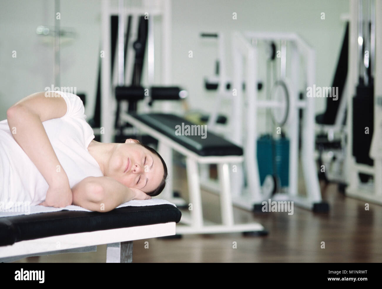 Young Woman Sleeping in the Gym Stock Photo