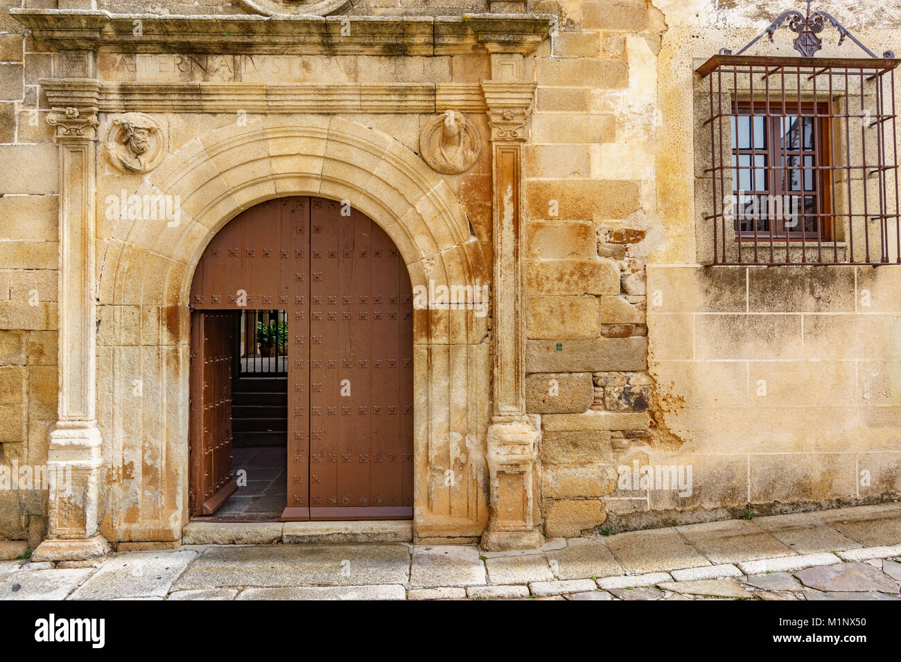 Old stone facade with wooden door Stock Photo - Alamy