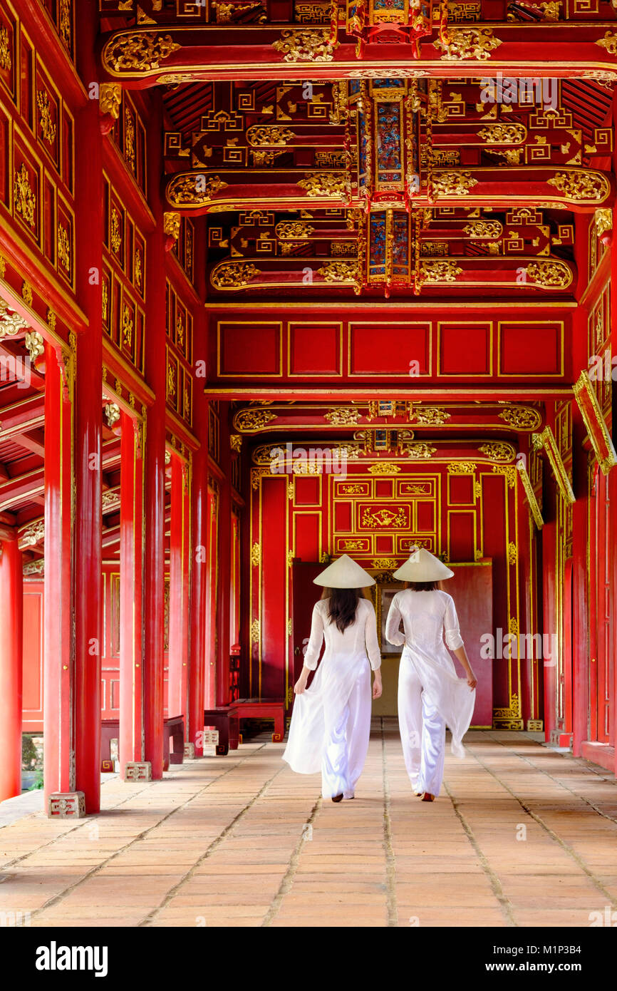 Two women in traditional Ao Dai dress and Non La conical hats in the Forbidden Purple City of Hue, UNESCO, Thua Thien Hue, Vietnam, Indochina, Asia Stock Photo