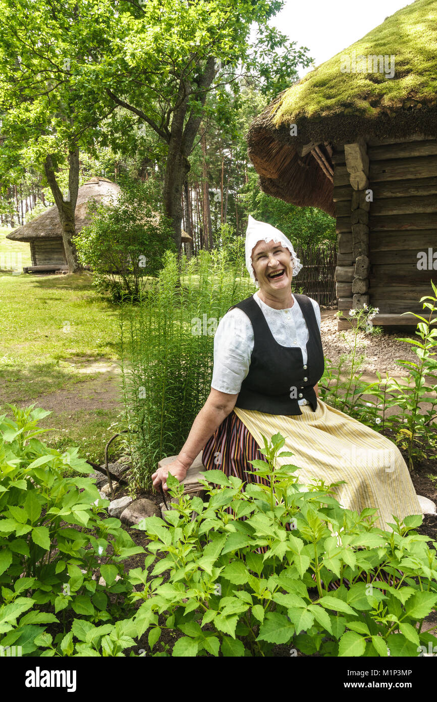 Woman in traditional dress outside a 17th century farmstead, Latvian Ethnographic Open Air Museum, Riga, Latvia, Europe Stock Photo