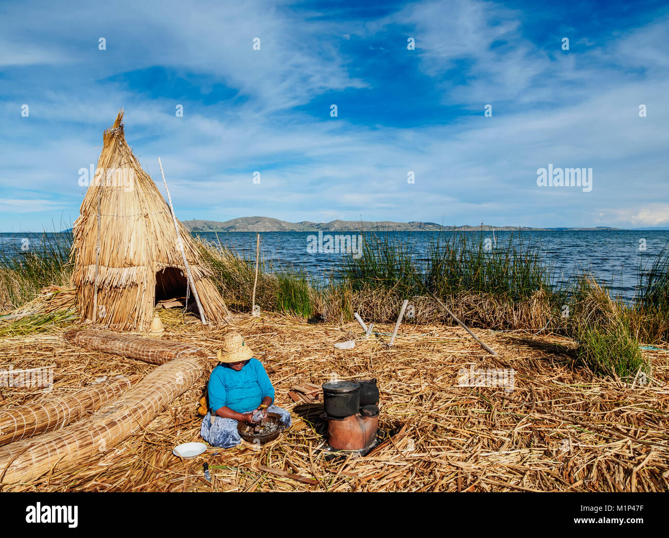 Native Uro Lady cooking, Uros Floating Islands, Lake Titicaca, Puno Region, Peru, South America Stock Photo