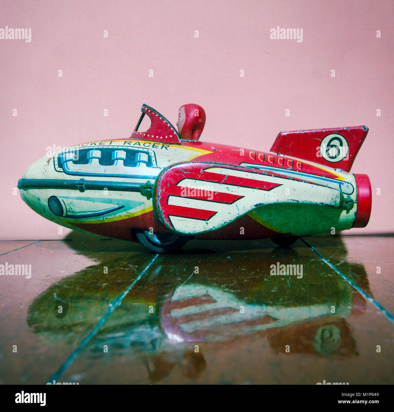 retro rocket tin toy close up on a wooden floor with reflection Stock Photo