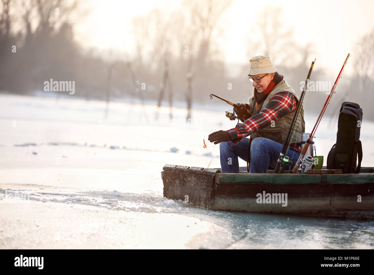 Old man fishing in boat with bait Stock Photo