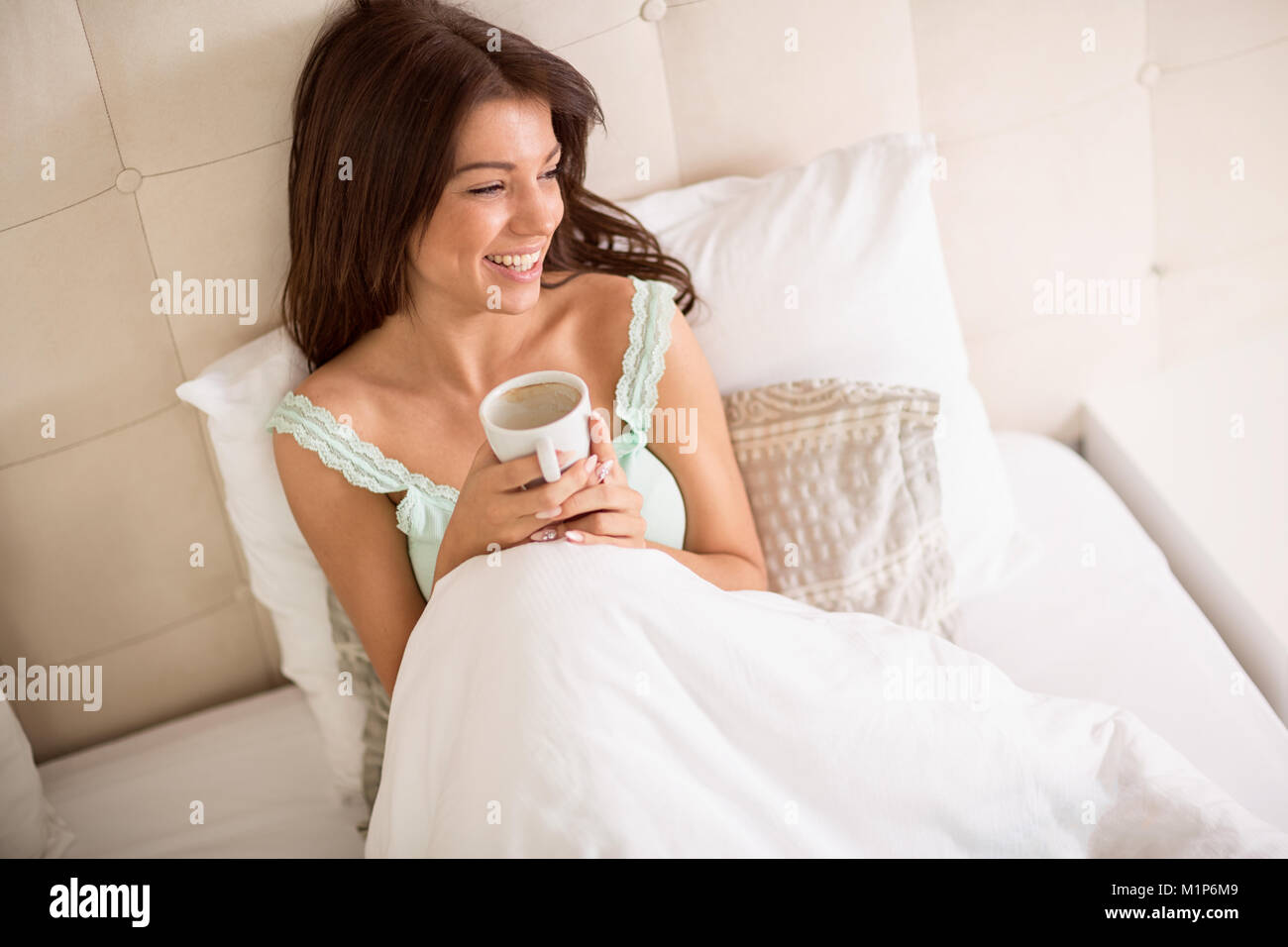 Nice girl in bed hold cup of coffee in the morning Stock Photo
