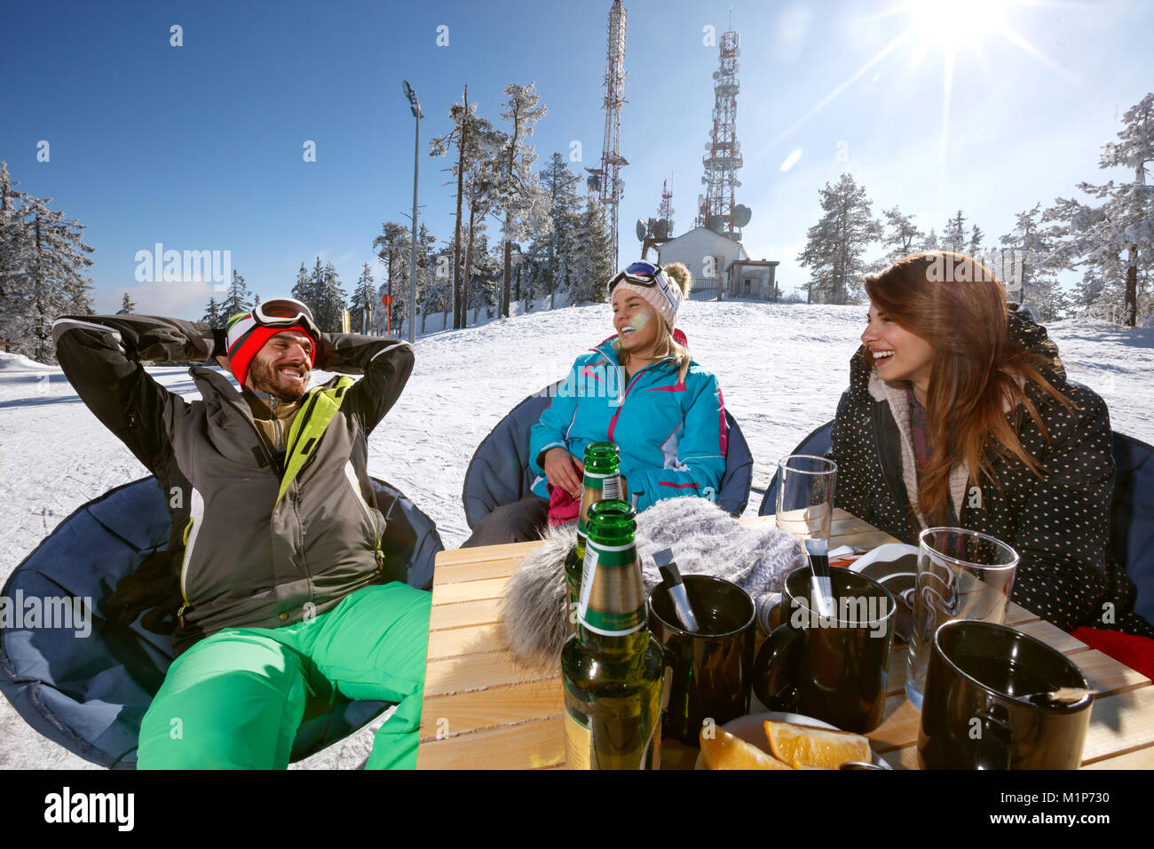 Group skiers enjoying together in cafe outdoor on ski terrain Stock Photo
