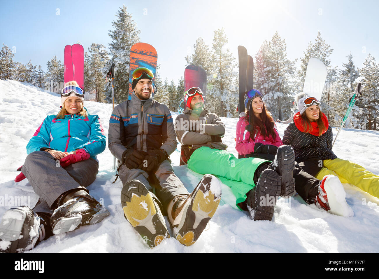 Group of skiers sitting on snow and resting Stock Photo