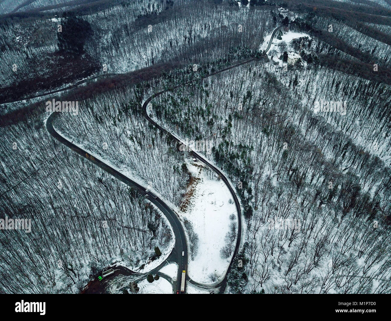 Snowy forest and road. Aerial view from a drone looking down Stock ...