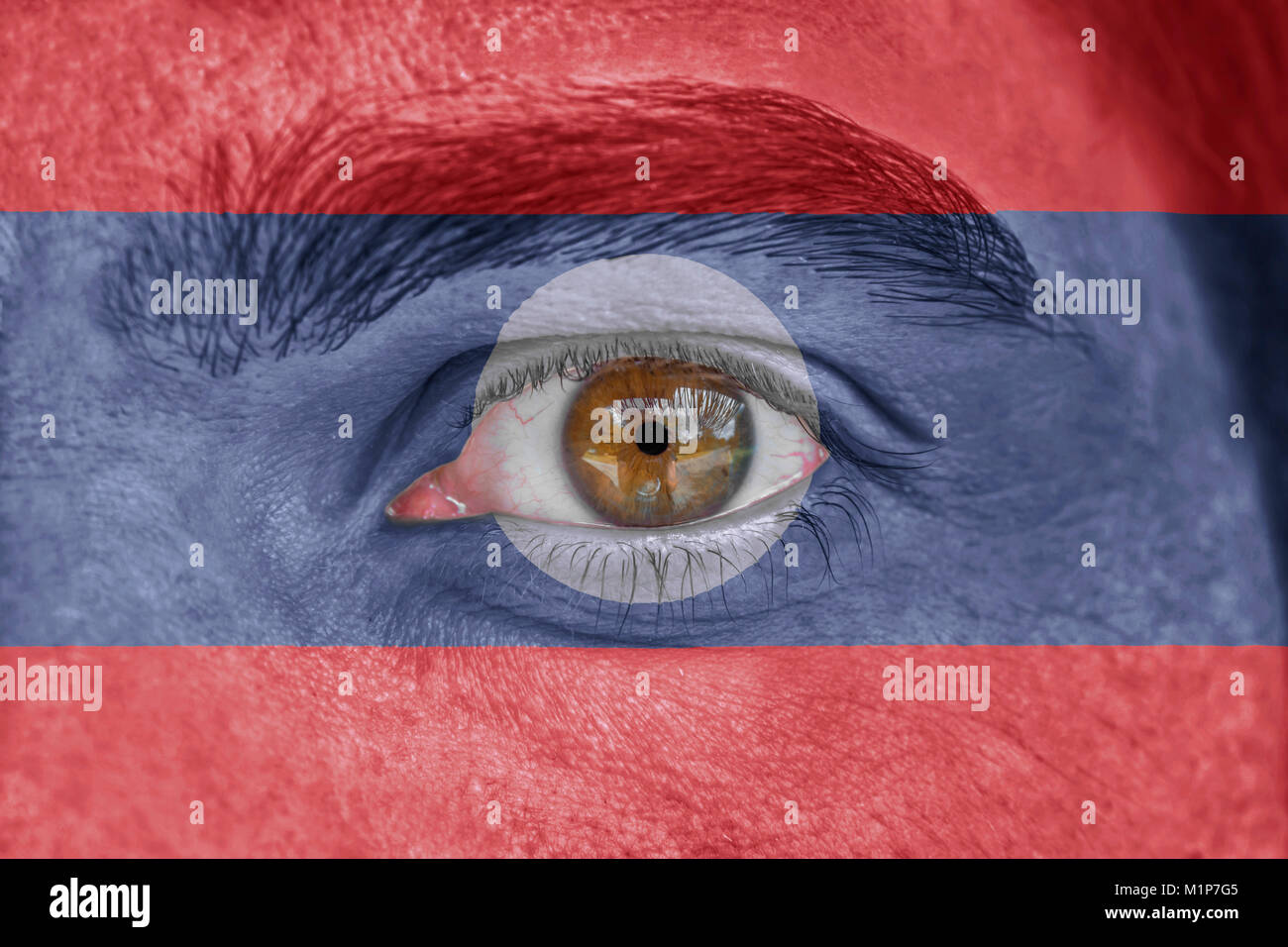 Human face and eye painted with flag of Laos Stock Photo