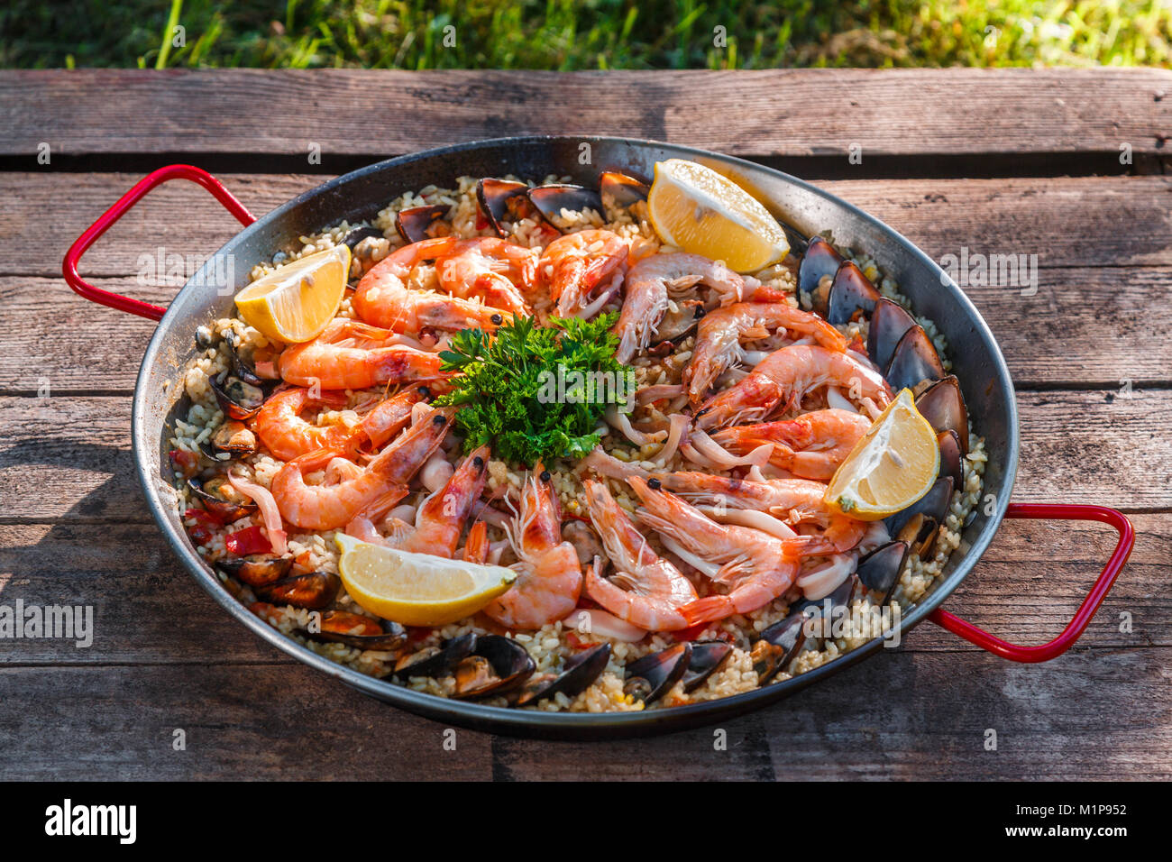 Traditional seafood paella in the fry pan on a wooden old table, top view Stock Photo