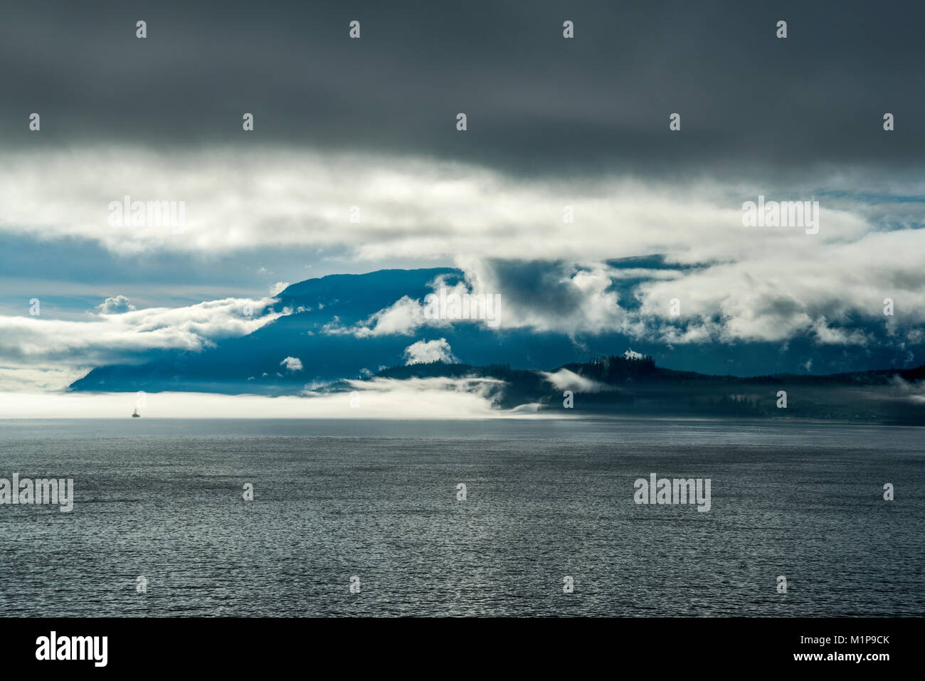 Franklin Range at Vancouver Island, shrouded with clouds, view from ferry crossing Broughton Strait on its way to Alert Bay, British Columbia, Canada Stock Photo