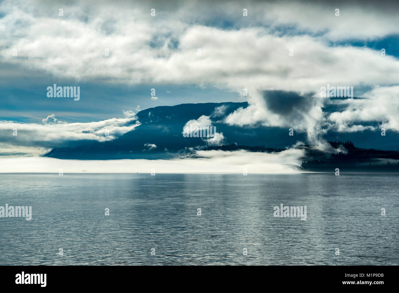 Franklin Range at Vancouver Island, shrouded with clouds, view from ferry crossing Broughton Strait on its way to Alert Bay, British Columbia, Canada Stock Photo