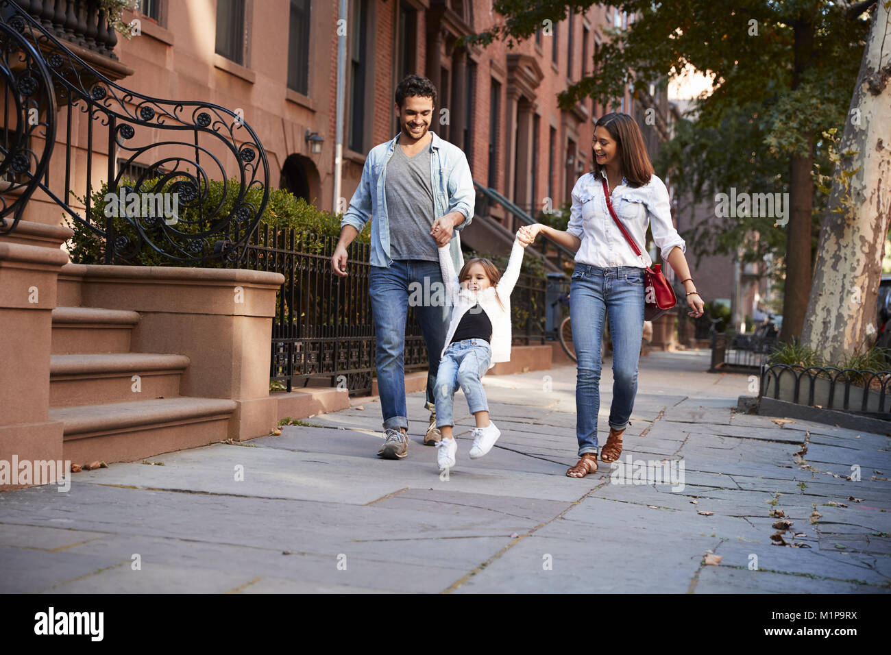 Family taking a walk down the street Stock Photo