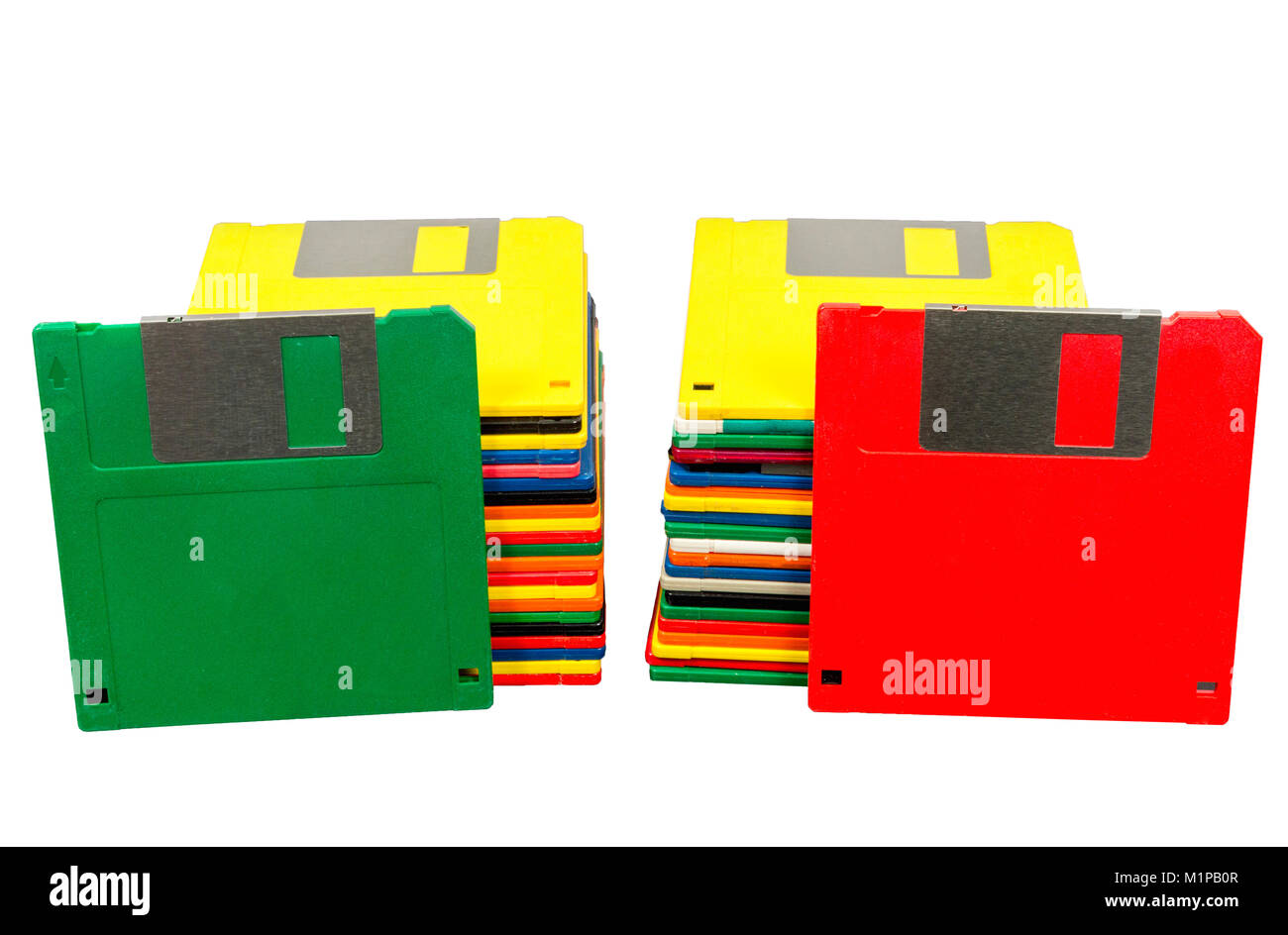 Horizontal shot of two stacks of old plastic multicolored disks.  A green disk is leaning against one stack and a red disk against the other.  Fronts  Stock Photo