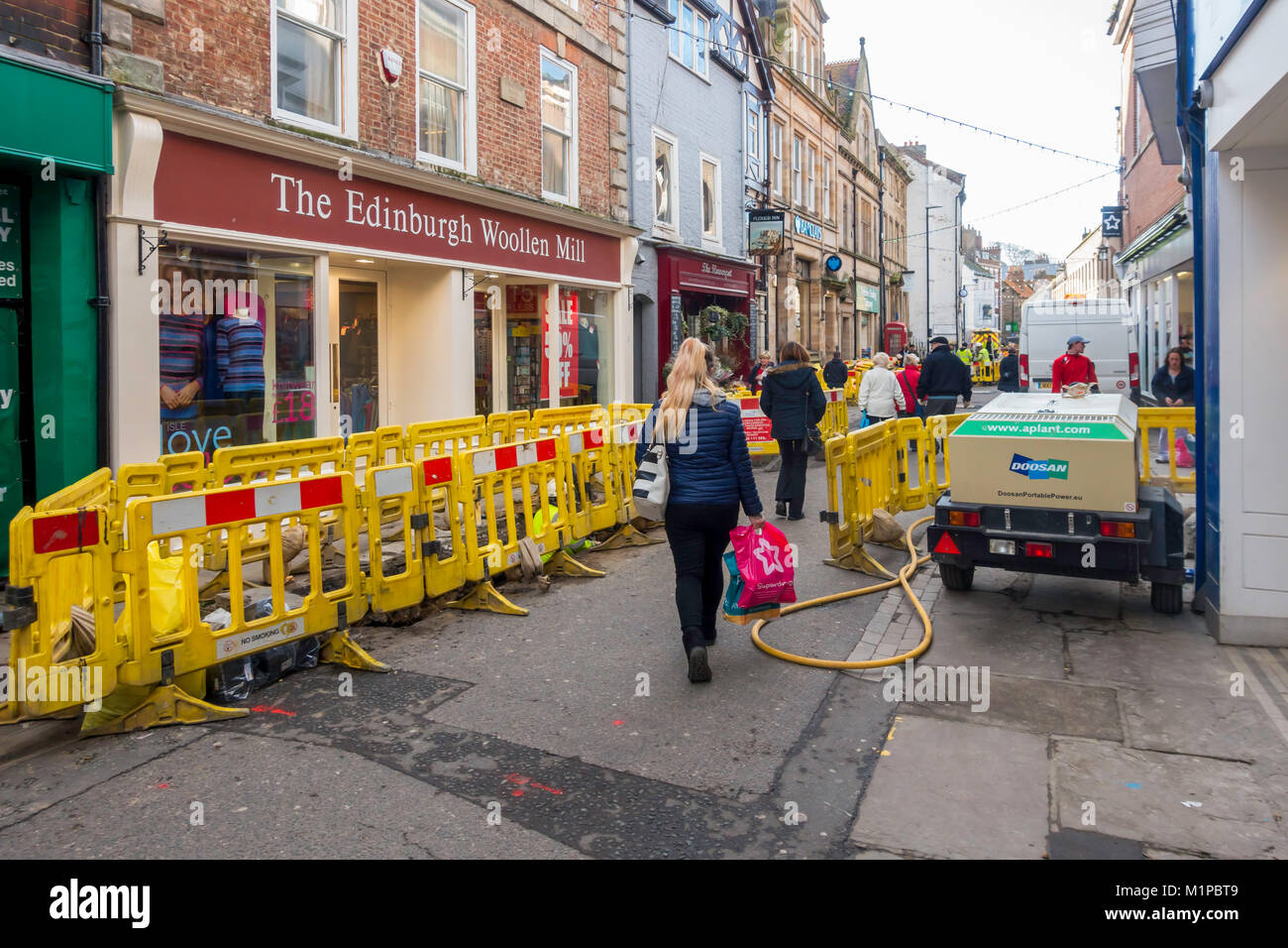 Contractors replacing a gas main in pedestrianised shopping street Baxtergate Whitby North Yorkshire England UK Stock Photo