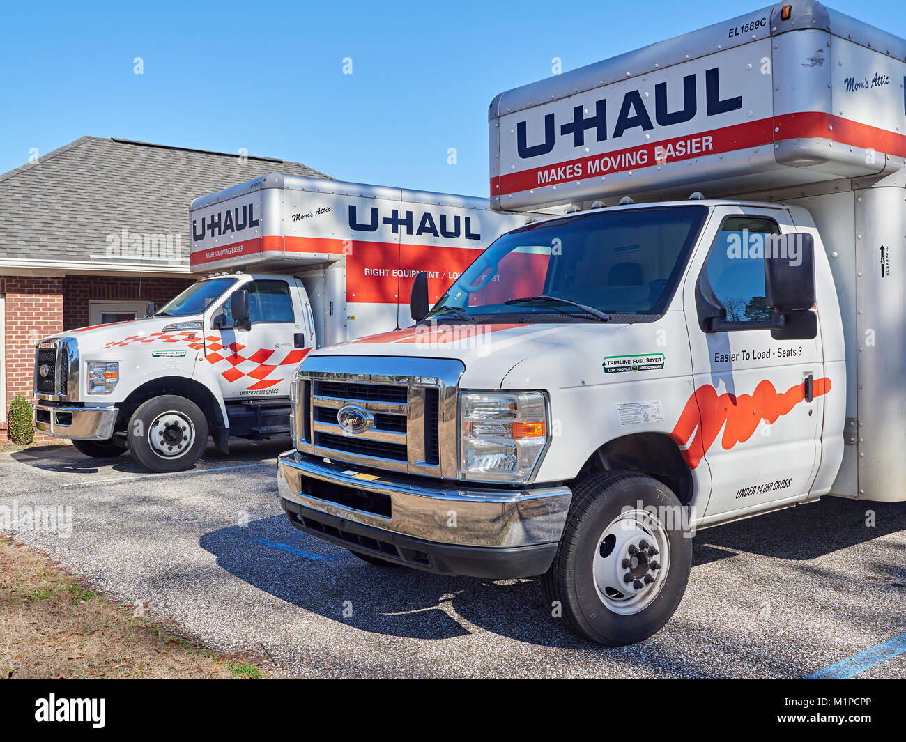 Two Uhaul self moving trucks or vans parked and ready for rental at a Uhaul and storage facility in Montgomery Alabama, United States. Stock Photo