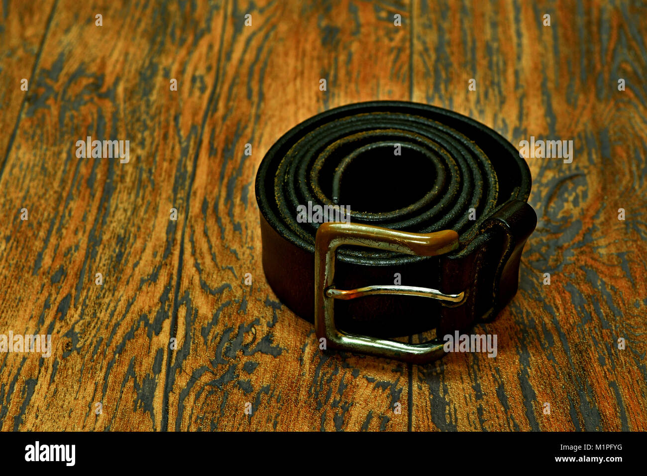 men's leather belt sport style and men's necktie by Gucci and wooden floor Stock Photo