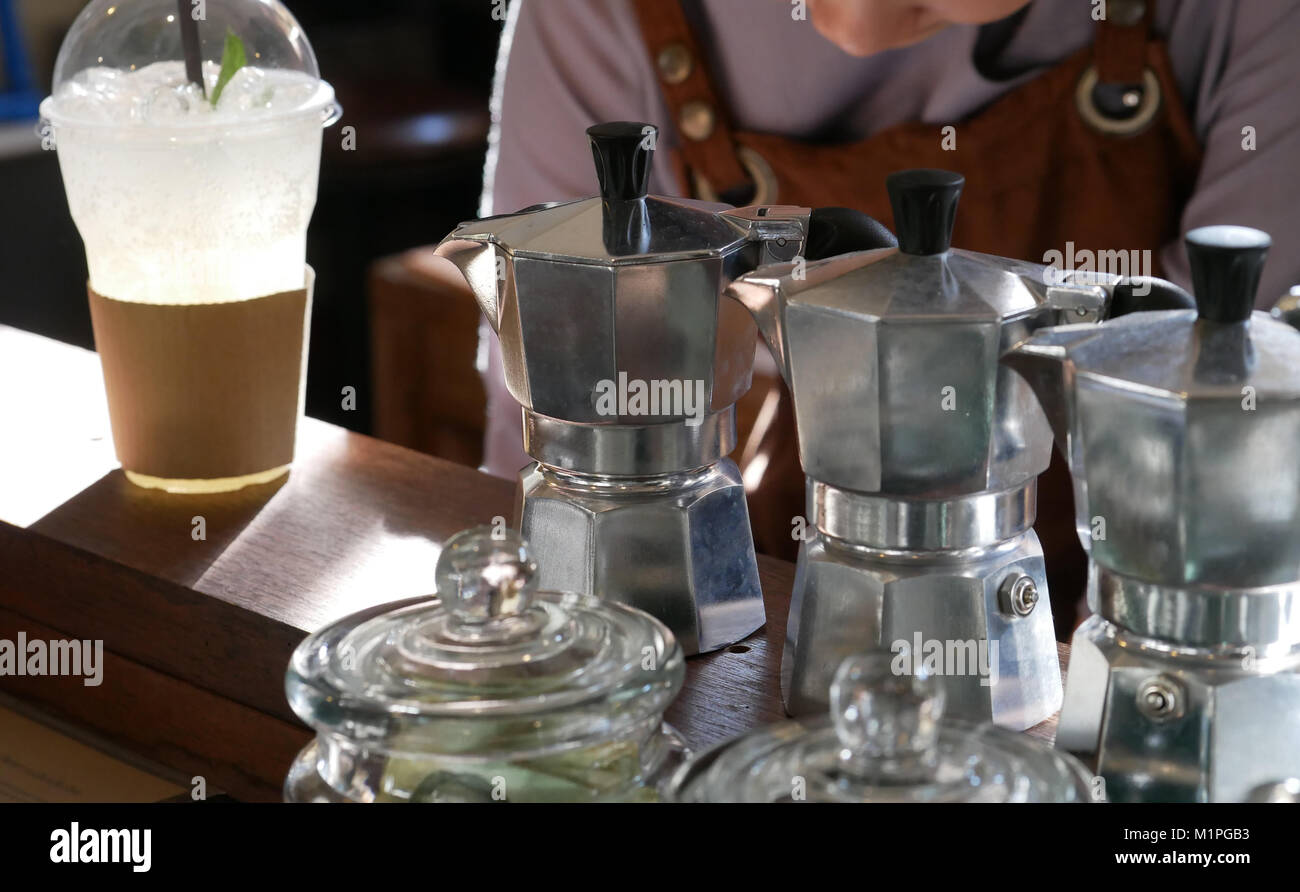 aluminum pot coffee maker on bar counter & barista in cafe. stovetop