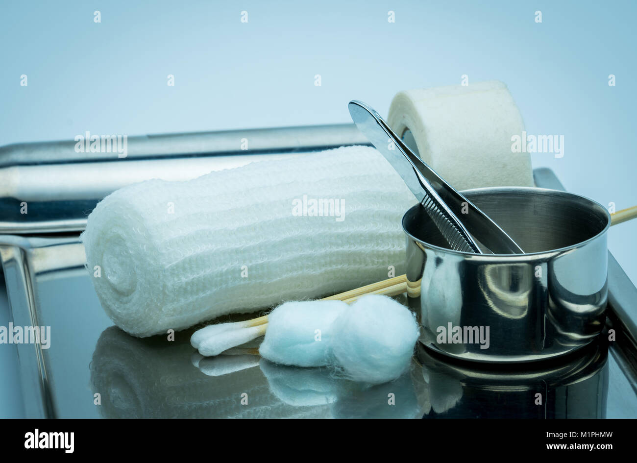 Wound care dressing set on stainless steel plate. Cotton ball with