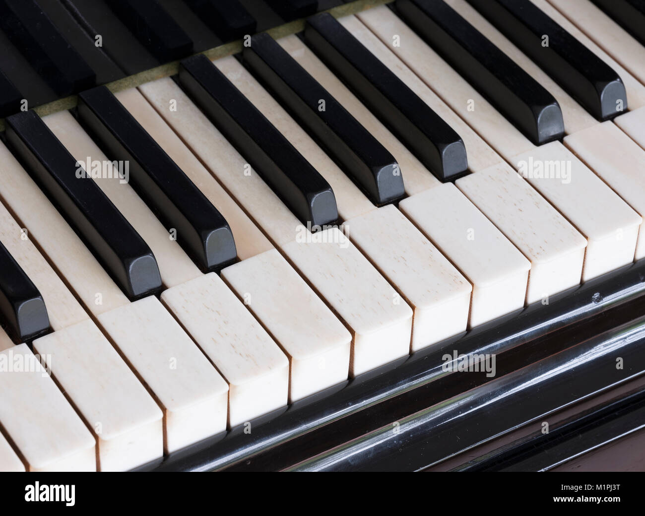 closeup of black and white keys on old ivory keyboard of antique