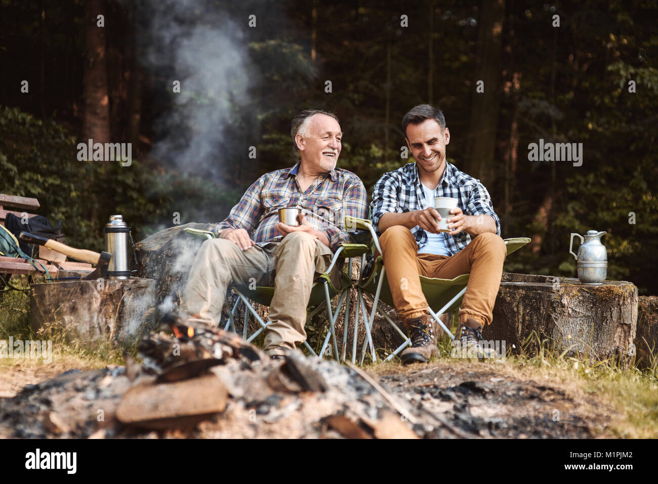 Two fishermen camping in forest Stock Photo