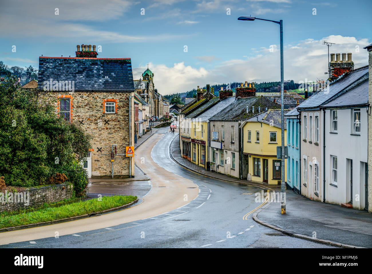 A typically Cornish winters rainy day with sunny intervals looking down the the main A390 into Lostwithiel, Cornwall. Coloured cottages line the road Stock Photo