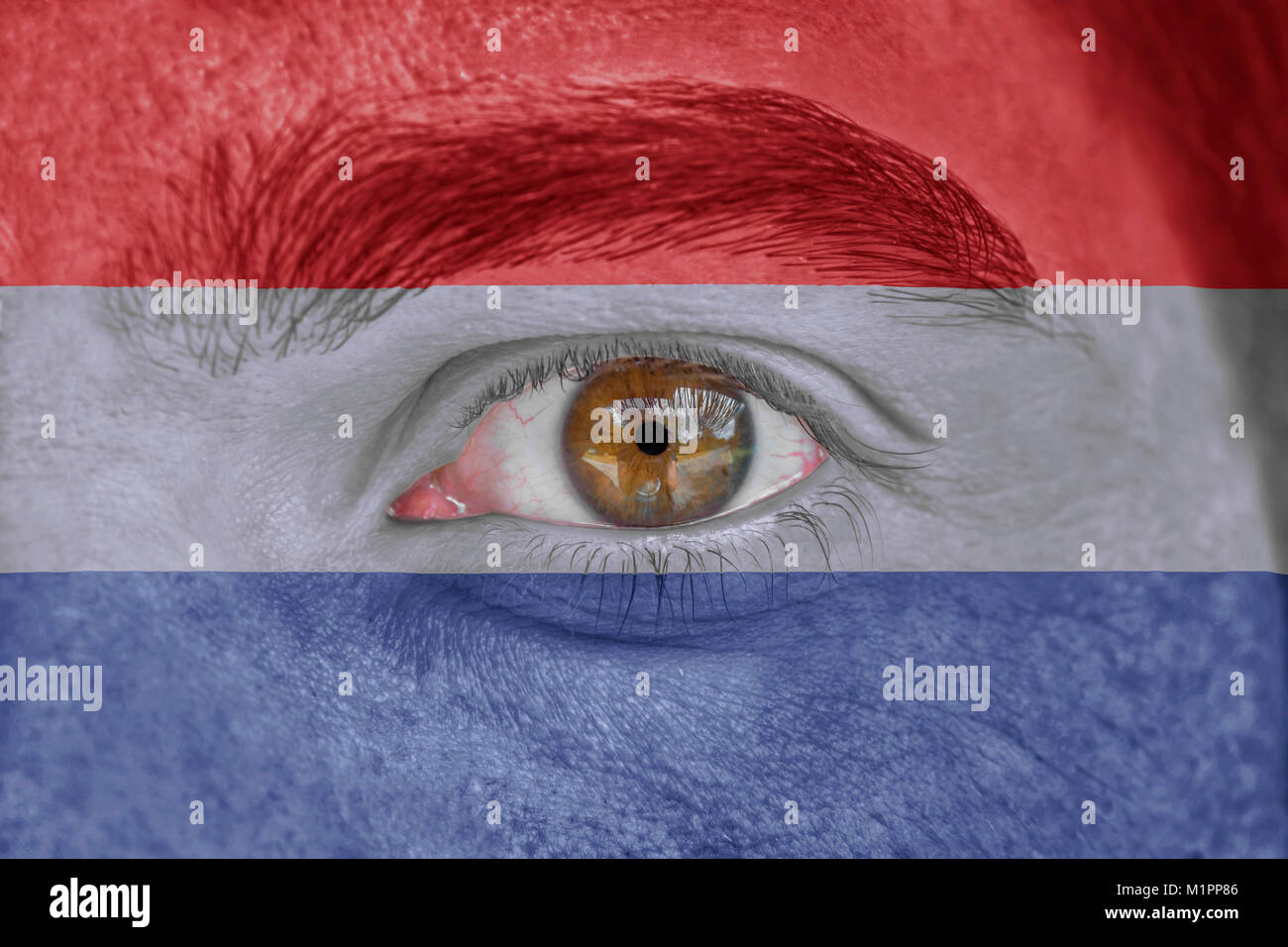 Human face and eye painted with flag of Netherlands Stock Photo