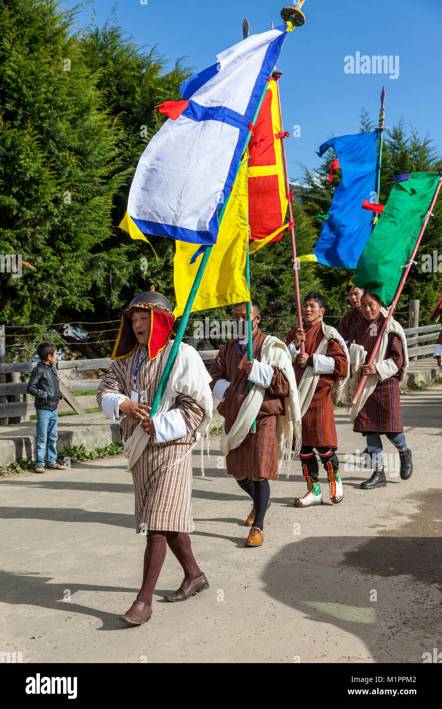 Bumthang, Bhutan.  Religious Procession Approaching Jambay Lhakhang Monastery.  Men Wearing Traditional Gho. Stock Photo